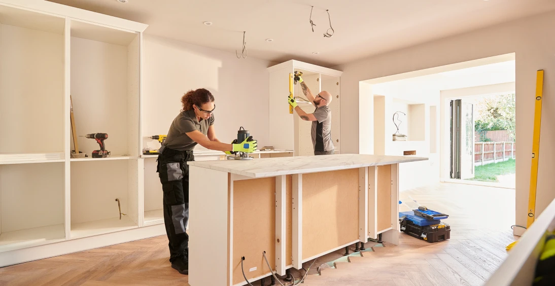 Kitchen renovation with workers installing cabinets